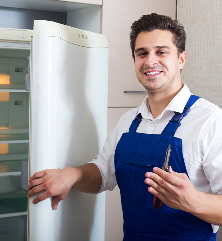 tradesman holding screwdriver and fridge door